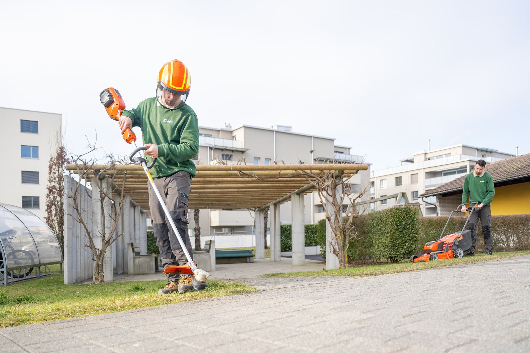 Gärtner mit Freischneider auf einem Vorplatz